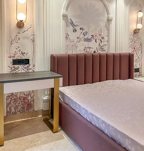 Elegant bedroom with floral walls and plush headboard