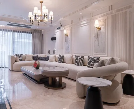 Elegant luxury living room with a large curved sofa and chandelier.