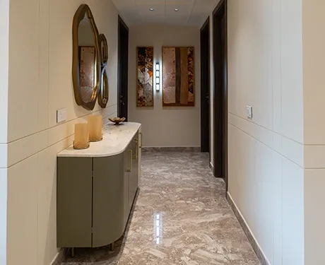 Elegant hallway with sleek storage, marble flooring, and decor