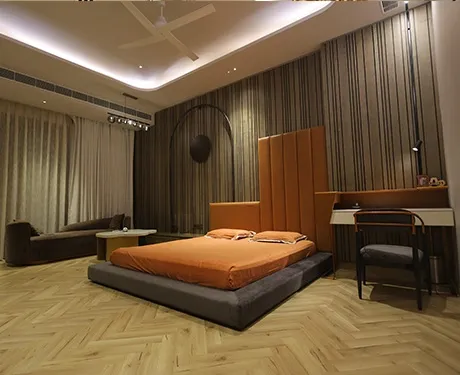 This modern bedroom uses bold orange accents and striking textures.