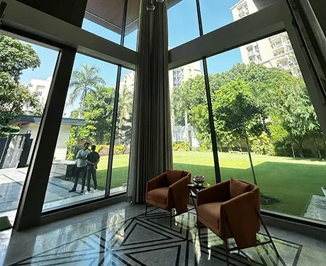 This stunning high-ceiling room offers a gorgeous view of greenery.