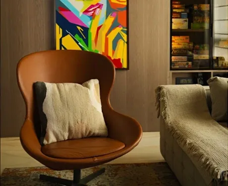Stylish leather accent chair beside sofa and art at home